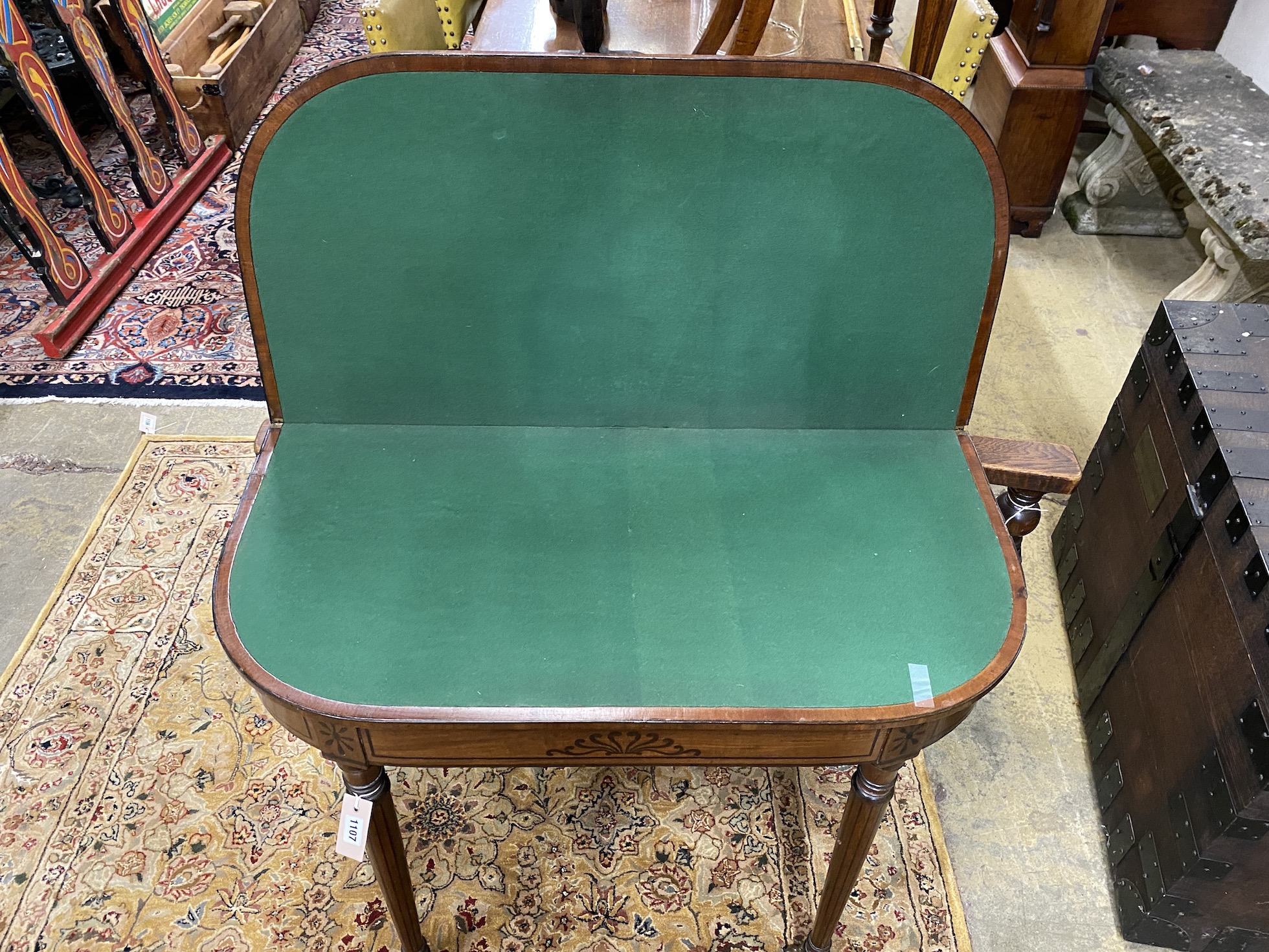 A Regency ebony inlaid mahogany D shaped folding card table, width 92cm, depth 46cm, height 73cm